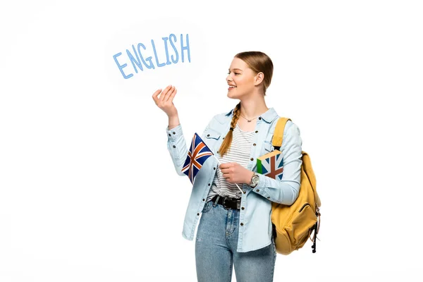 Посміхаючись гарненькому студентові з рюкзаком тримає книгу, мову бульбашку з англійським написом і британський прапор ізольований на білому — стокове фото