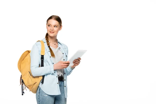 Sonriente bonita estudiante con mochila sosteniendo tableta digital aislada en blanco - foto de stock