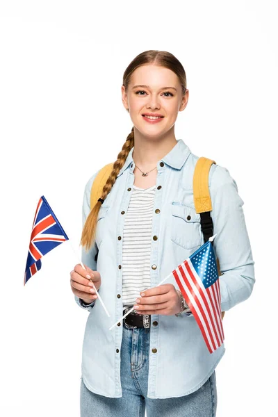 Smiling girl with braid and backpack holding flags of america and united kingdom isolated on white — Stock Photo