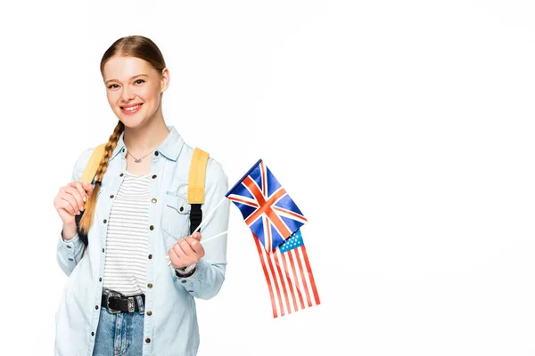 Fille heureuse avec tresse et sac à dos tenant des drapeaux d'Amérique et royaume uni isolé sur blanc — Photo de stock