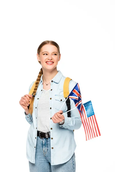 Happy girl with braid and backpack holding flags of america and united kingdom isolated on white — Stock Photo