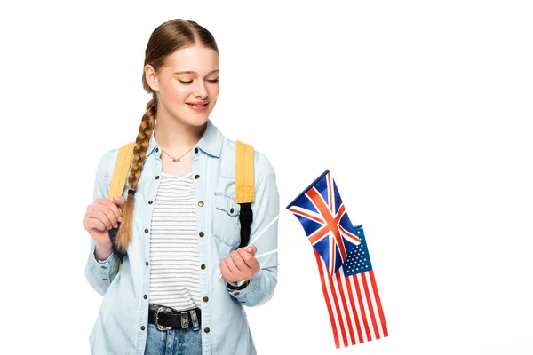 Fille souriante avec tresse et sac à dos tenant drapeaux d'Amérique et royaume uni isolé sur blanc — Photo de stock