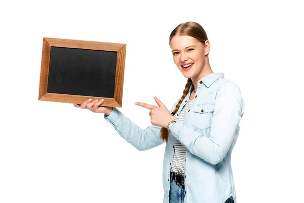 Souriant jolie fille avec tresse pointant vers tableau blanc vide isolé sur blanc — Photo de stock