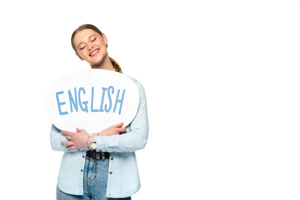 Smiling girl with braid and closed eyes holding speech bubble with English lettering isolated on white — Stock Photo