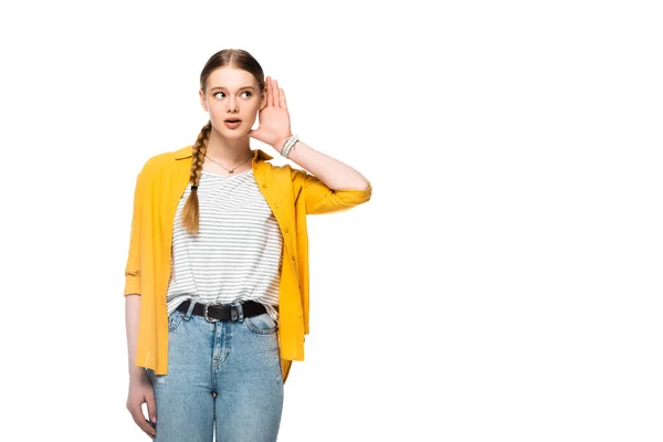 Chica atractiva escuchando con la mano cerca de la oreja aislada en blanco - foto de stock