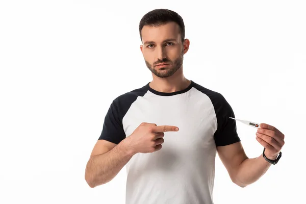 Hombre enfermo señalando con el dedo el termómetro digital aislado en blanco - foto de stock