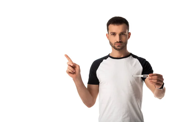 Hombre enfermo señalando con el dedo y sosteniendo termómetro digital aislado en blanco - foto de stock