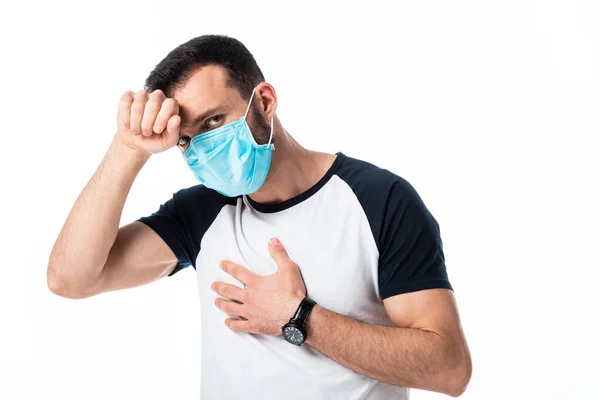 Sick man in medical mask touching forehead isolated on white — Stock Photo