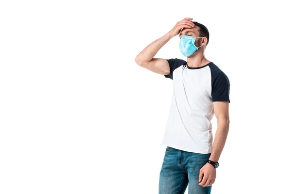 Ill man in medical mask touching forehead isolated on white — Stock Photo