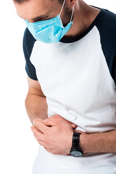 Homem doente em máscara médica tocando estômago isolado em branco — Fotografia de Stock