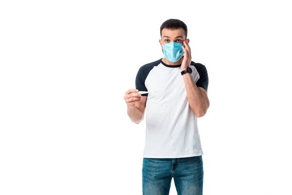 Hombre enfermo en máscara médica sosteniendo termómetro digital aislado en blanco - foto de stock