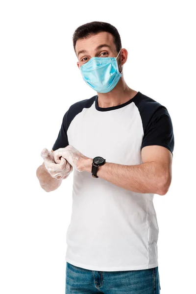 Людина в медичній масці миє руки і дивиться на камеру ізольовано на білому — стокове фото