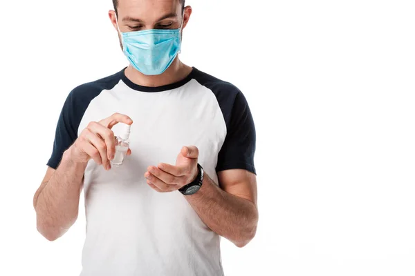 Man in medical mask holding spray bottle with antibacterial liquid near hand isolated on white — Stock Photo