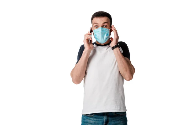 Shocked man in medical mask talking on smartphone isolated on white — Stock Photo
