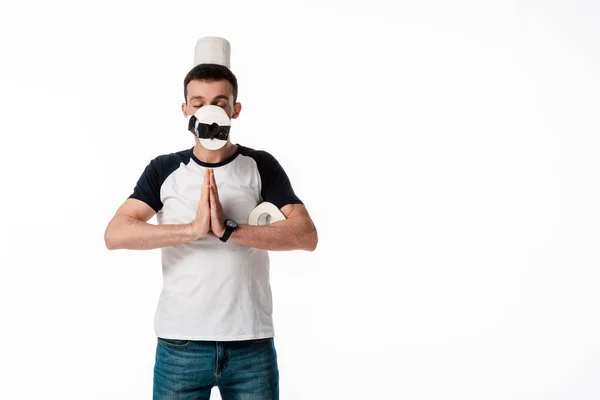 Homem com mãos de oração e papel higiênico no rosto isolado em branco — Fotografia de Stock