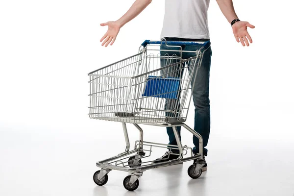 Cropped view of man gesturing while standing near empty shopping cart on white — Stock Photo