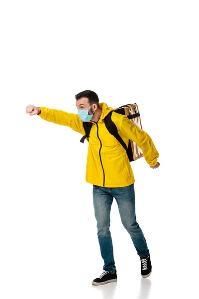 Delivery man in medical mask and backpack with order gesturing on white — Stock Photo