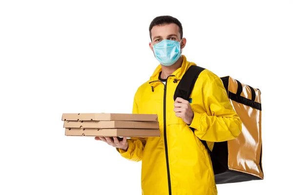 Fattorino in maschera medica contenente scatole di cartone per pizza isolate su bianco — Foto stock