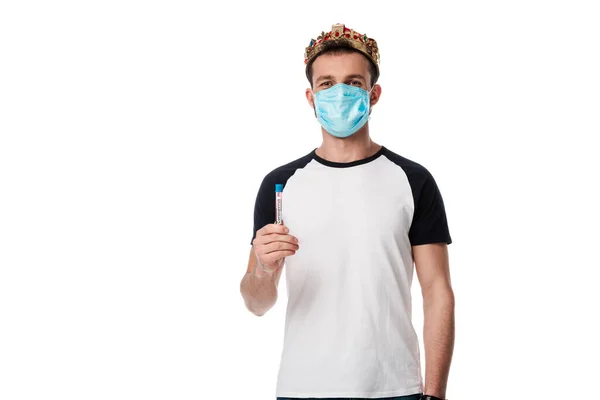 Man in medical mask and crown holding test tube with coronavirus blood sample lettering isolated on white — Stock Photo