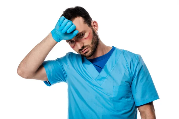 Médico cansado con marcas en la cara tocando la frente aislado en blanco - foto de stock