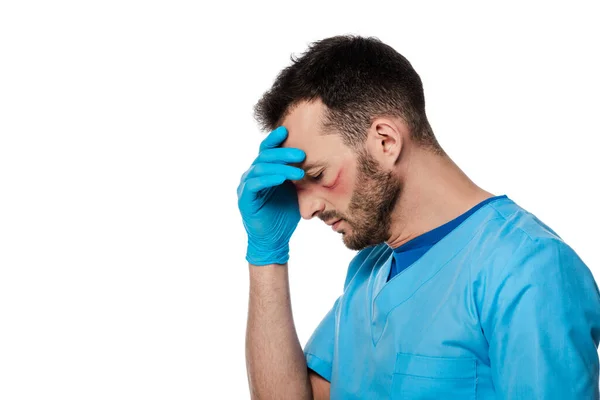 Exhausto médico con marcas en la cara tocando la cabeza aislado en blanco - foto de stock