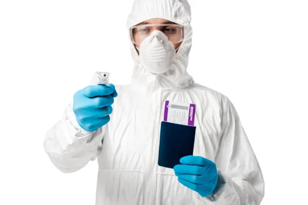 Selective focus of man in hazmat suit holding pyrometer and passport with boarding pass isolated on white — Stock Photo