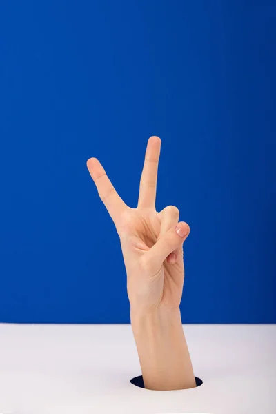 Vista cortada da mulher mostrando sinal de paz isolado no azul — Fotografia de Stock