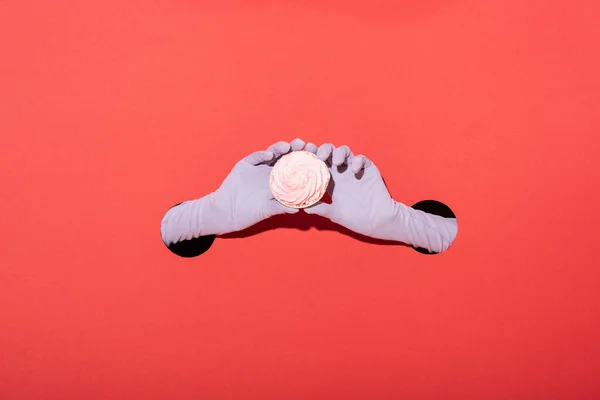 Cropped view of woman in gloves holding tasty dessert on red — Stock Photo