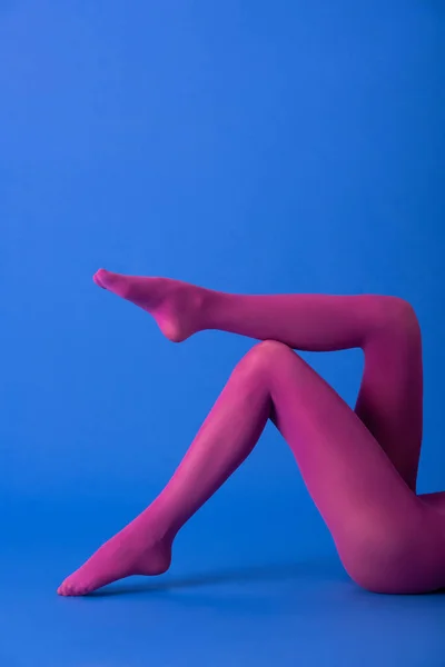 Cropped view of woman in bright purple tights on blue — Stock Photo