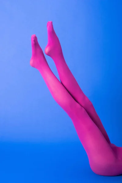 Cropped view of woman in purple tights on blue — Stock Photo