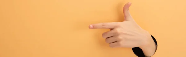 Plano panorámico de mujer señalando con el dedo en naranja — Stock Photo