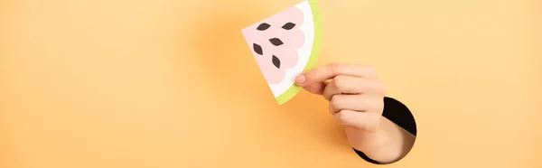 Plano panorámico de mujer sosteniendo sandía de papel sobre naranja - foto de stock