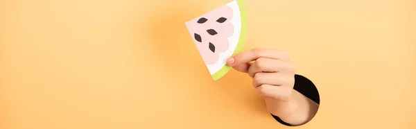 Panoramic shot of woman holding paper watermelon on orange — Stock Photo