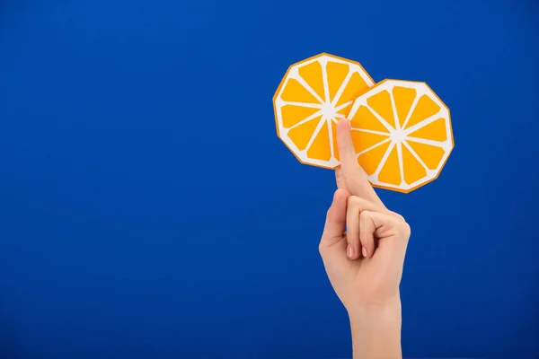 Abgeschnittene Ansicht einer Frau mit Papierschnitt orange isoliert auf blau — Stockfoto