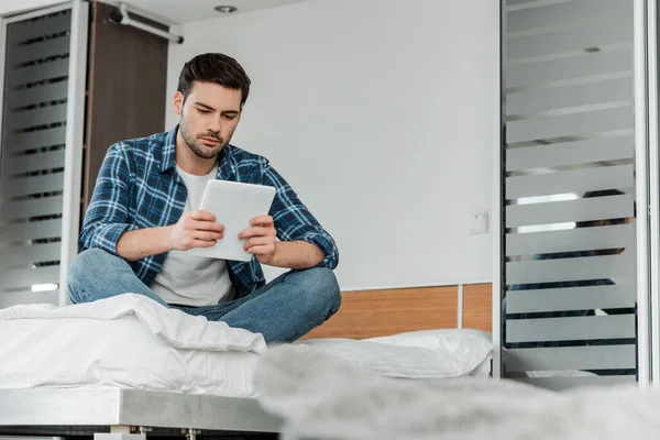 Selektiver Fokus des Mannes im geflochtenen Hemd mit digitalem Tablet auf dem heimischen Bett — Stockfoto