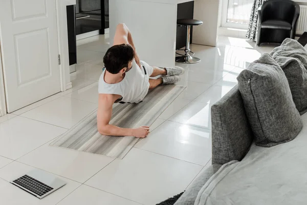 Homem fazendo prancha durante o treinamento em esteira de fitness em casa — Fotografia de Stock