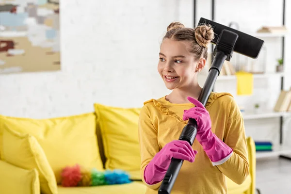 Дитина з пилососом посміхається і дивиться у вітальню — Stock Photo