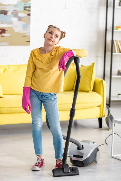 Enfant fatigué dans des gants en caoutchouc avec aspirateur dans le salon — Photo de stock