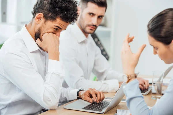 Focus selettivo dell'uomo d'affari afroamericano che utilizza laptop vicino a colleghi multietnici in carica — Foto stock