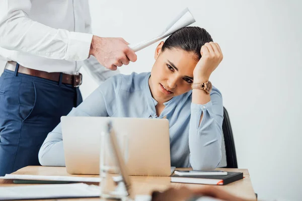 Selective focus of businessman holding document near head of sad mexican colleague in office — Stock Photo