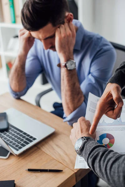 Selektiver Fokus des Geschäftsmannes, der mit dem Finger auf die Armbanduhr seines Bürokollegen zeigt — Stockfoto