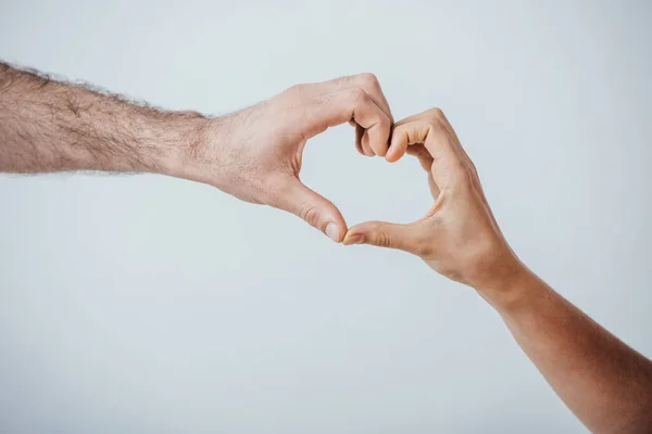 Vista recortada de los hombres mostrando gesto de amor aislado en gris - foto de stock