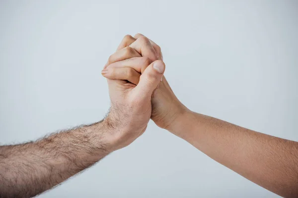 Vue recadrée des hommes tenant les mains isolées sur gris — Photo de stock