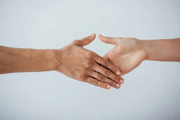 Vista ritagliata degli uomini che si tengono per mano stretta isolata su grigio — Foto stock