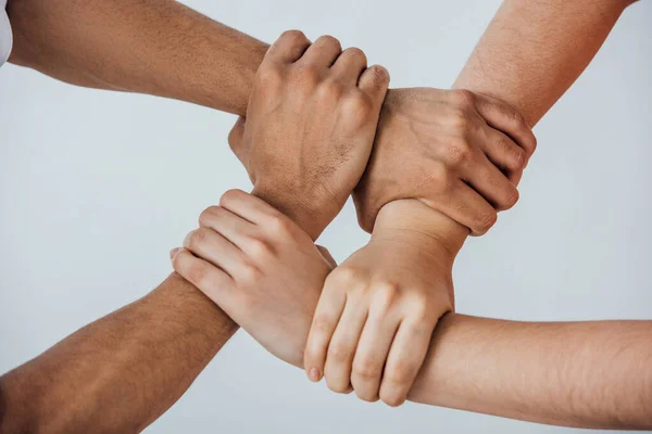 Cropped view of multiethnic men doing unity gesture isolated on grey — Stock Photo