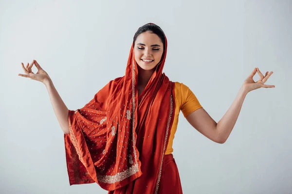 Sorridente ragazza indiana meditando isolato su grigio — Foto stock