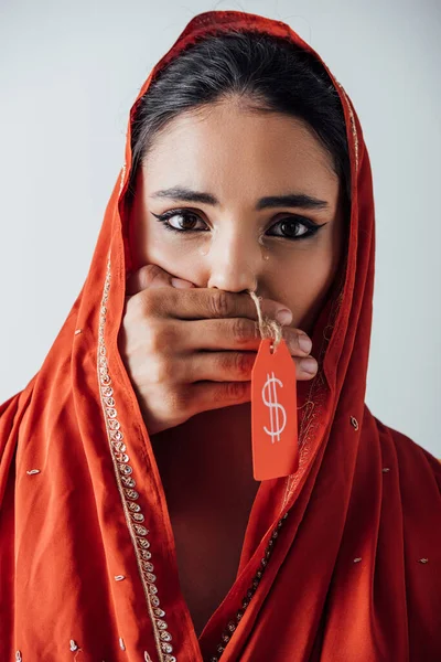 Male hand holding price tag with dollar sign and covering mouth to crying indian woman in sari isolated on grey — Stock Photo
