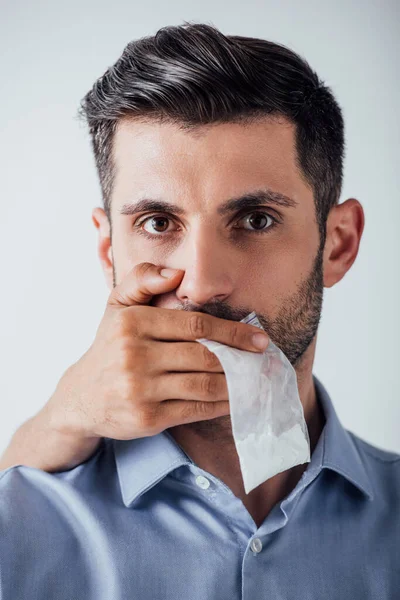 Emballage à main masculin contenant de la cocaïne tout en couvrant la bouche de l'homme isolé sur gris — Photo de stock