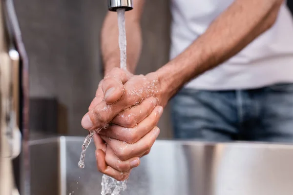 Enfoque selectivo del hombre lavándose las manos en casa - foto de stock