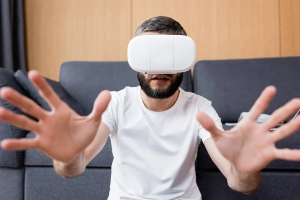 Selective focus of man using vr headset in living room — Stock Photo